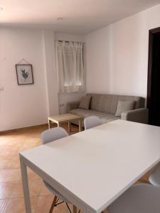 a living room with a couch and a table and chairs at Asís 20 in Medina Sidonia +2 photos