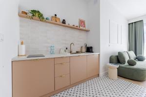 a kitchen with a sink and a couch in a room at Roosevelta Residence in Łódź
