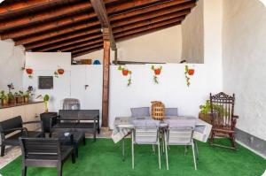 a patio with a table and chairs on a green floor at La Corralada de Merón in San Vicente de la Barquera