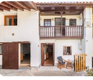 a white house with a balcony and a table at La Corralada de Merón in San Vicente de la Barquera