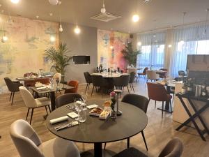a restaurant with tables and chairs in a room at Hotel Garibaldi in Vercelli