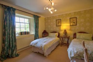 a bedroom with two beds and a window at West Compton Manor in Dorchester