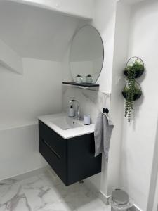 Un baño con un lavabo negro y un espejo. en Maison 100m2 uniquement famille, couple & professionnel, en Villeparisis 29 fotos más