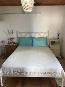 a bedroom with a white bed with blue pillows at Koralia Summer House in Lióta