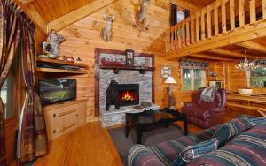 a living room with a fireplace in a log cabin at Holden On in Pigeon Forge
