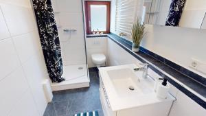 a white bathroom with a sink and a toilet at Fewo Seenah in Radolfzell am Bodensee +17 photos