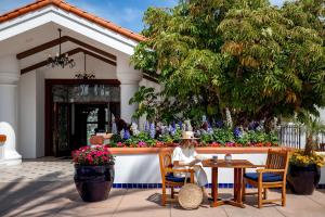 a woman sitting at a table outside a building at Omni La Costa Resort & Spa Carlsbad in Carlsbad