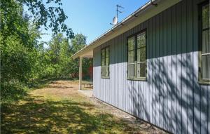 a green and white building next to a yard at Awesome Home In Aakirkeby With Wifi in Vester Sømarken +9 photos