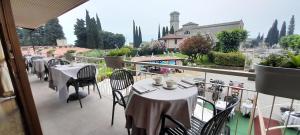 a patio with tables and chairs on a balcony at Hotel Adria & Resort in Toscolano Maderno