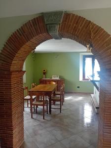 une salle à manger avec une arcade avec une table et des chaises dans l'établissement La casa di Bobo, à Pian degli Ontani