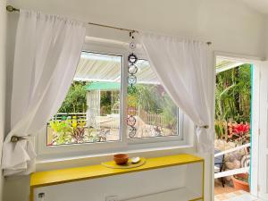 a window with a bowl on a yellow table in a room at Nan La Tigra in El Rosario
