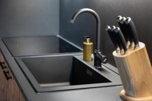 a kitchen counter with a sink with a knife holder at Schöneben Appartementen Top 3 in Wald im Pinzgau +12 photos