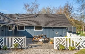 a blue house with a picnic table in front of it at Holiday Home Rødby - 08 in Kramnitse