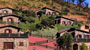 un grupo de casas en una colina con árboles en La Portilla de Cabezo, en Cabezo 22 fotos más