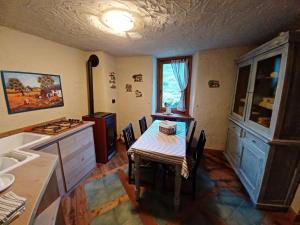 a kitchen with a table and a counter with a sink at Le Village De Fours in Rhêmes-Notre-Dame