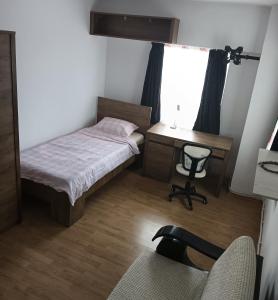a bedroom with a bed and a desk and a chair at Apartament Superb Arena Mall in Bacău