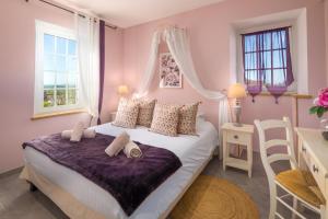 Un dormitorio con una cama, un escritorio y ventanas. en Domaine de Campagnac - Spa & Sauna, en Carsac-Aillac