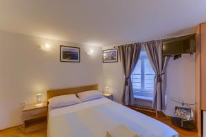 a bedroom with a large bed and a large window at Guest House City Center in Korčula