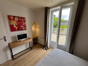a bedroom with a bed and a window at Appartement Terrasse Barbizon in Barbizon