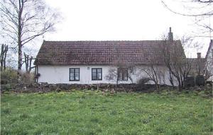 a white house with a red roof in a field at Holiday Home Komstad Stengravar Gärsnäs in Smedstorp