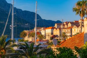a town with boats in a harbor with palm trees at Guest House City Center in Korčula