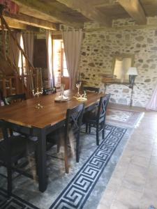 una sala da pranzo con tavolo e sedie in legno di La petite Salamandre bleue a La Croisille-sur-Briance