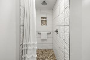 a bathroom with a shower with a white shower curtain at Willow - 99 Ridge Lane in Branson +30 photos