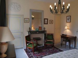 a bedroom with a fireplace and a table and chairs at Chambres d'hôtes Château de Courcelette in Hem