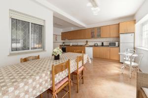 a kitchen and dining room with a table and chairs at Consolação Beach Villa in Atouguia da Baleia