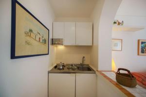 a small kitchen with a sink and a counter at La Piccola, Capri in Capri