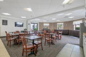 a dining room with tables and chairs and a tv at The Landmark Inn in Fort Bragg