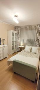 a bedroom with a large bed and a table and a desk at Apartament Bella Zdrój in Głuchołazy