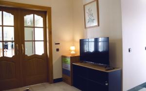 un salon avec une télévision sur une commode et une porte dans l'établissement Casa del Sol y la Luna Apartamento Atardecer, à Tíjola
