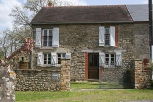 an old stone house with a red door at Maison L'Abeille in Saint-Plantaire