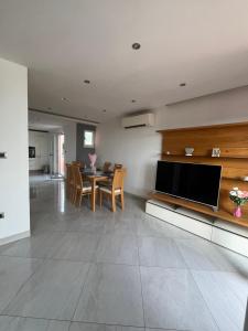 sala de estar con mesa y TV grande en Apartmani Agape, en Podstrana