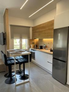 a kitchen with a table and a stainless steel refrigerator at Andromachi's House in Pefkochori
