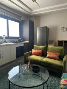 a living room with a green couch and a glass table at Studio meublé à Mermoz in Dakar