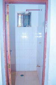 a bathroom with a shower with a window in it at Tarangwe Homestay & Hostels in Iringa