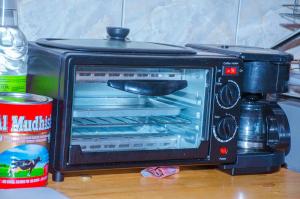 a toaster oven sitting on a table with an open door at Tarangwe Homestay & Hostels in Iringa