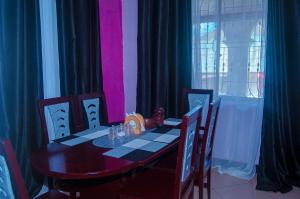 a dining room with a table and chairs and a window at Tarangwe Homestay & Hostels in Iringa +26 photos