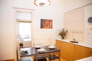 a dining room with a table and a kitchen at Eftihia's House in Egina