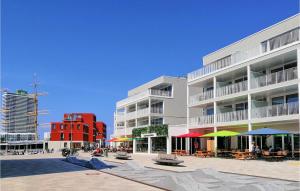 ein Gebäude mit Tischen und Sonnenschirmen davor in der Unterkunft Passatvilla - Apartment 6 in Travemünde