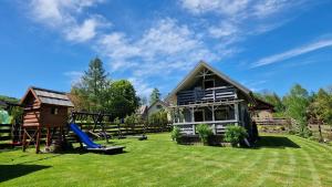 a house with a slide and a playground at Domek Dwojakówka in Ropa