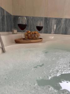 Dos copas de vino y un plato de comida en una bañera. en Apartmani Agape, en Podstrana 33 fotos más