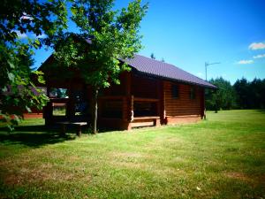 a log cabin with a bench in front of it at Ignaszówka in Radawa