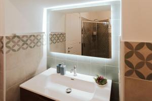 un bagno con lavandino e specchio di Casa Vacanze White Palace ad Alliste Altre 44 foto