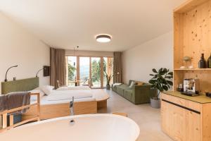 a bathroom with a bath tub and a bedroom at SCHILCHERLANDLEBEN - Hochgrail in Greisdorf