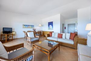 a living room with couches and a coffee table at Vila Palmeira Beach Resort in Lagos