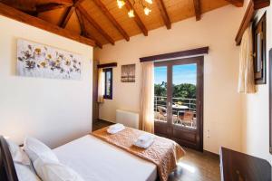 a bedroom with a bed and a sliding glass door at Villa Drimonas Erato by Villa Plus in Drymon