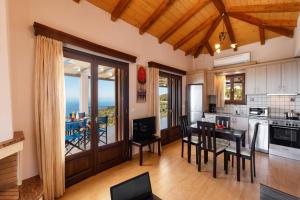 a kitchen with a table and chairs and a view of the ocean at Villa Drimonas Erato by Villa Plus in Drymon